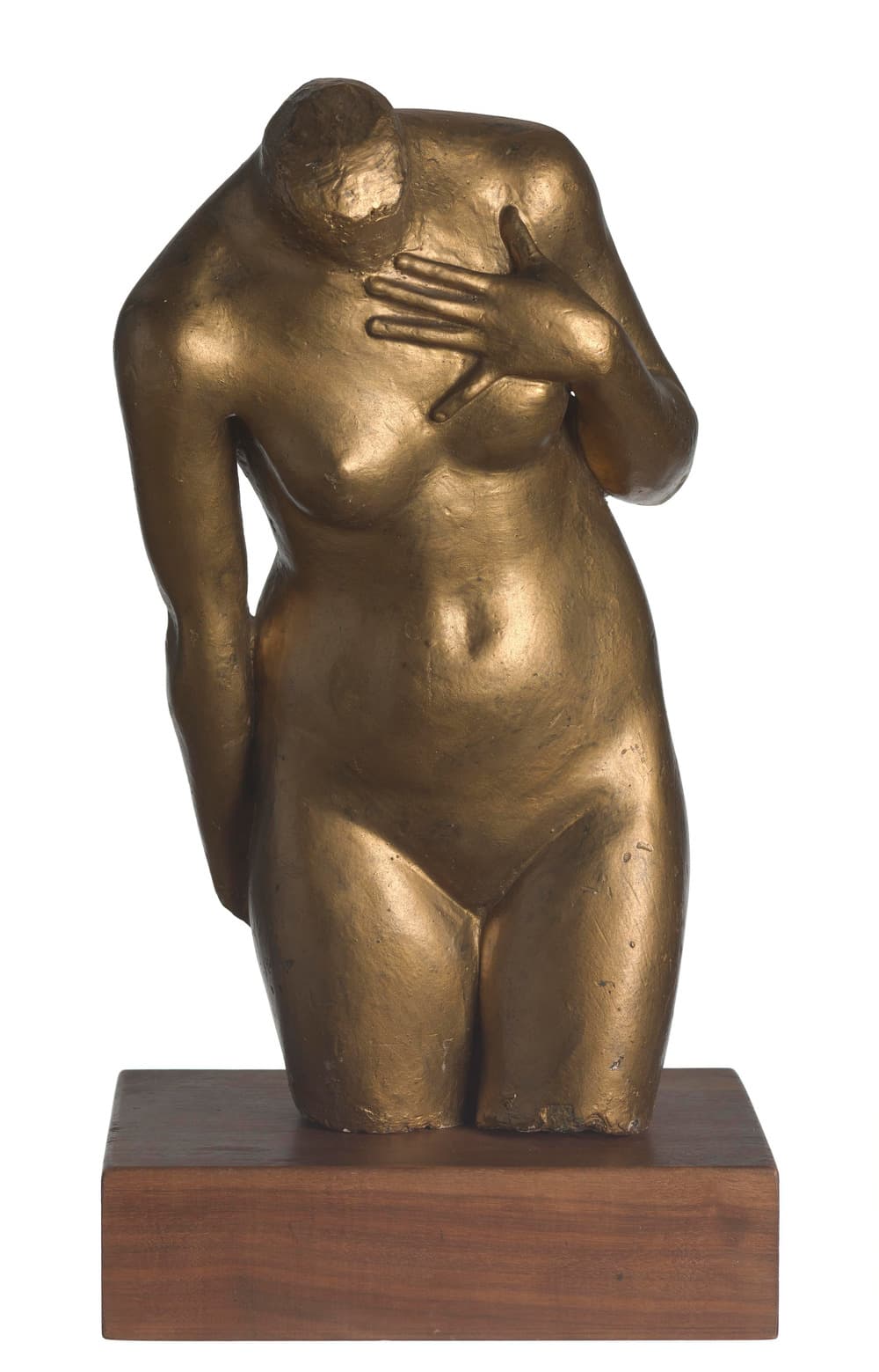 A woman's torso in plaster painted a dull dark gold, standing on a rectangular block of dark wood against a plain white ground. The body is cut off at the neck, where a rough cylindrical stump is left, at the top of one arm, above the wrist of the other, and across both thighs. It bends slightly forward and to the figure's right. The left hand is laid flat against the chest above the breast with the fingers spread; the right arm falls straight at the side and a little behind the body. Small pits and paint losses show on the hip and along the lower edge