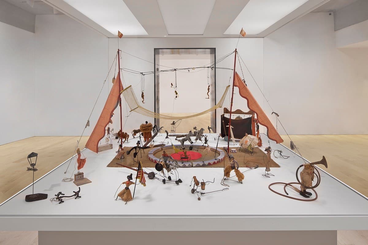Cirque Calder: dozens of small circus figures of wire, cloth and cork — acrobats, animals, a ringmaster — arranged as a miniature circus ring