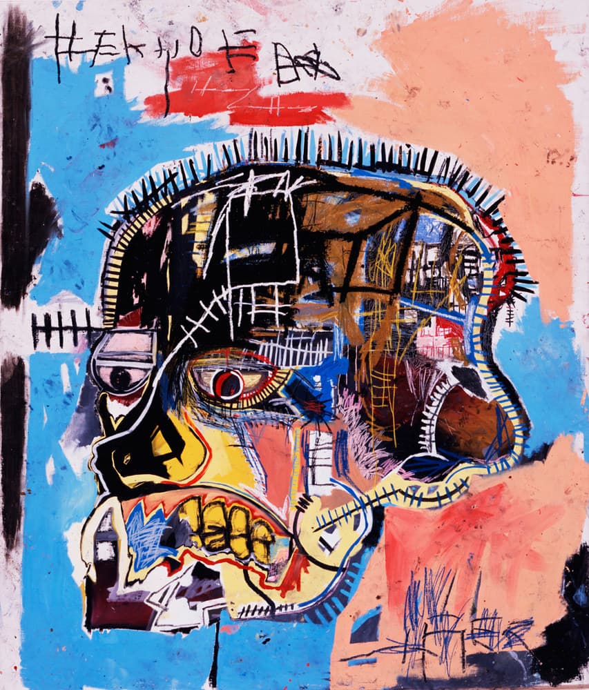 A large head painted as a skull fills the canvas against sky blue at the left and salmon pink at the right. The cranium is a dome of brown, ochre, black and yellow patches crossed by drawn ladders and grids, with a row of black spikes along the top. The left eye is a pale grey lozenge with a black pupil under a flat grey bar; the right eye is a yellow almond with a red ring around a dark pupil and black lashes radiating from the lid. A heavy black wedge with a yellow triangle stands in for the nose, and the mouth is a wide band of yellow teeth outlined in black with red and white gum lines. A row of black letterforms crossed by horizontal bars runs across the top of the canvas