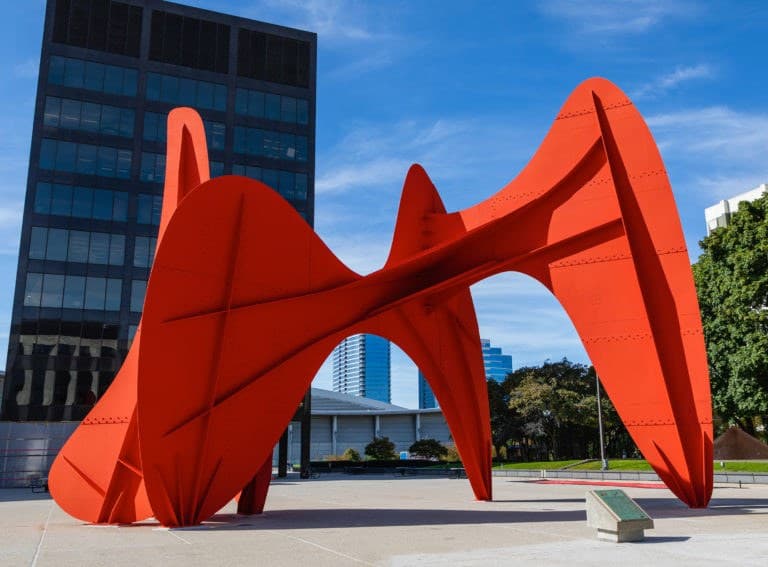 La Grande Vitesse: a large vermilion steel stabile of curving intersecting plates rising from a concrete civic plaza