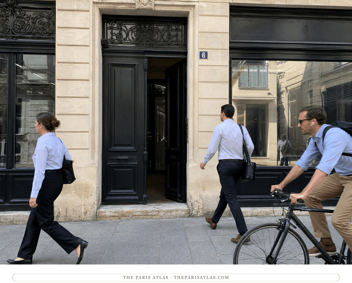 Office workers and a cyclist passing a black doorway marked number 6