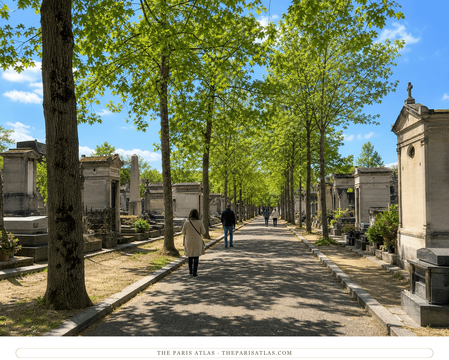 Visitors walking along a straight tree-lined avenue between tombs in Montparnasse Cemetery