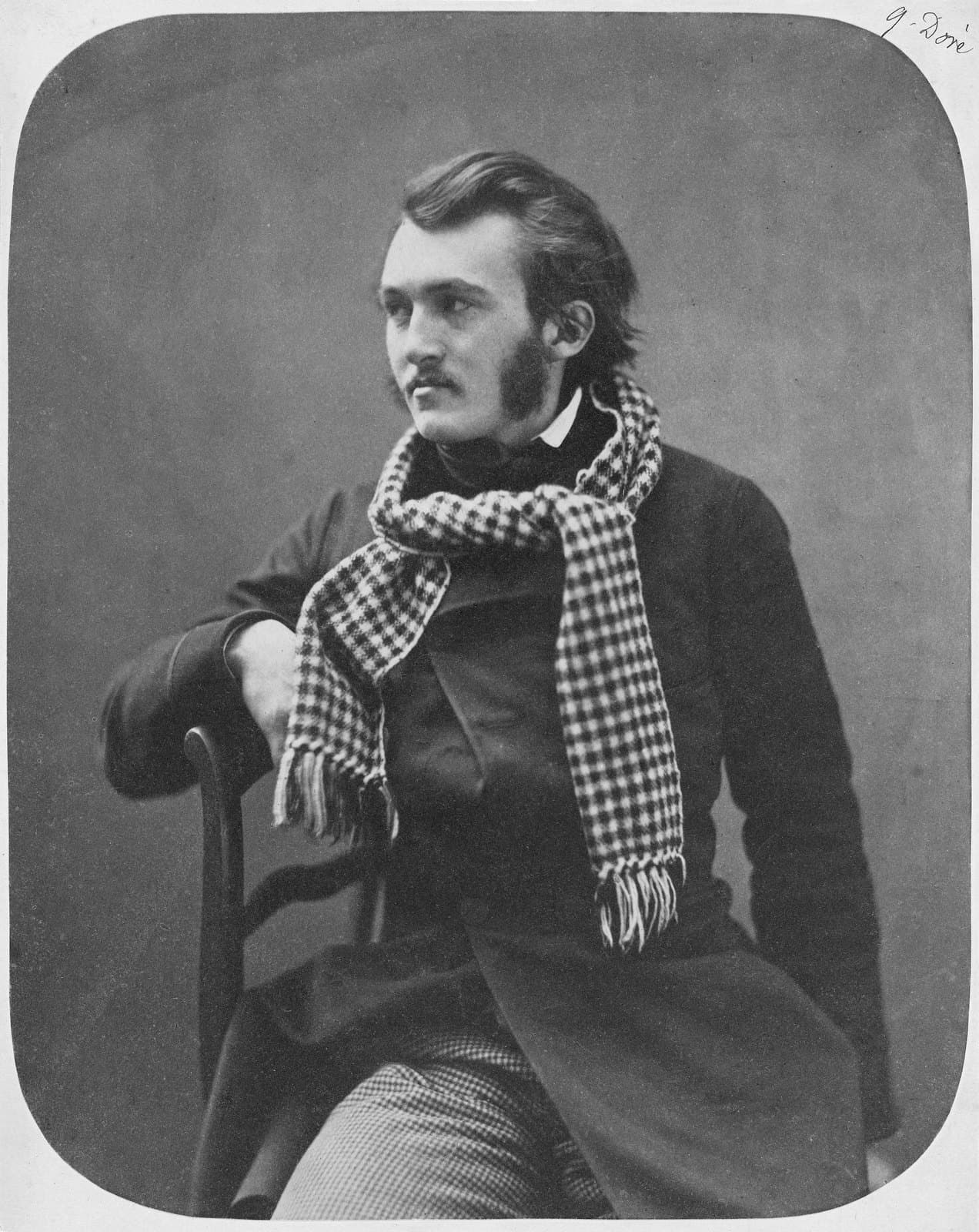 Studio photograph of Gustave Doré as a young man, seated, dark jacket, hair swept back, looking past the camera