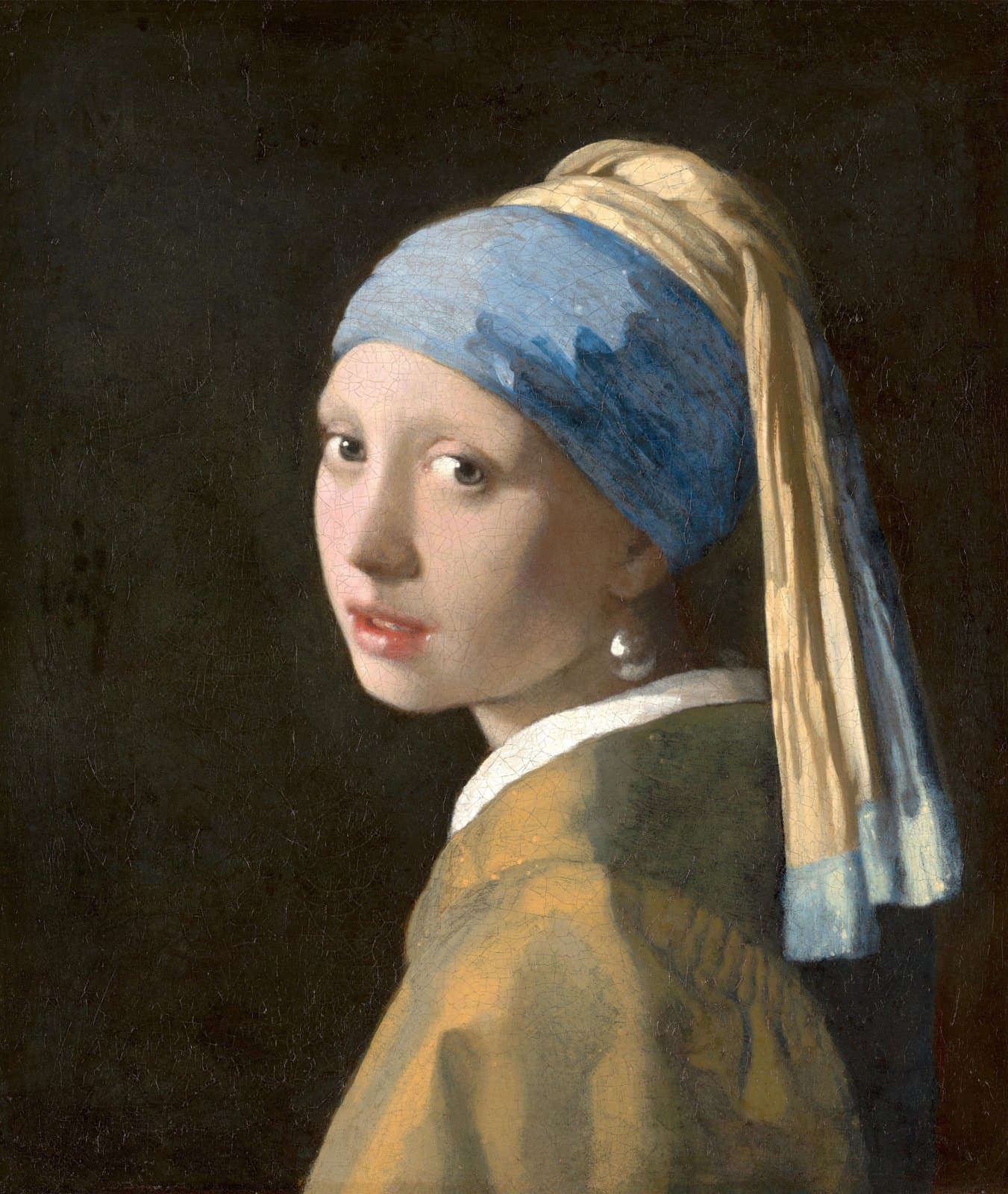 A girl seen from the shoulders up turns her head to look at the viewer over her left shoulder. She wears a blue and yellow turban, a plain brown jacket with a white collar, and a large pearl earring, against a dark background.