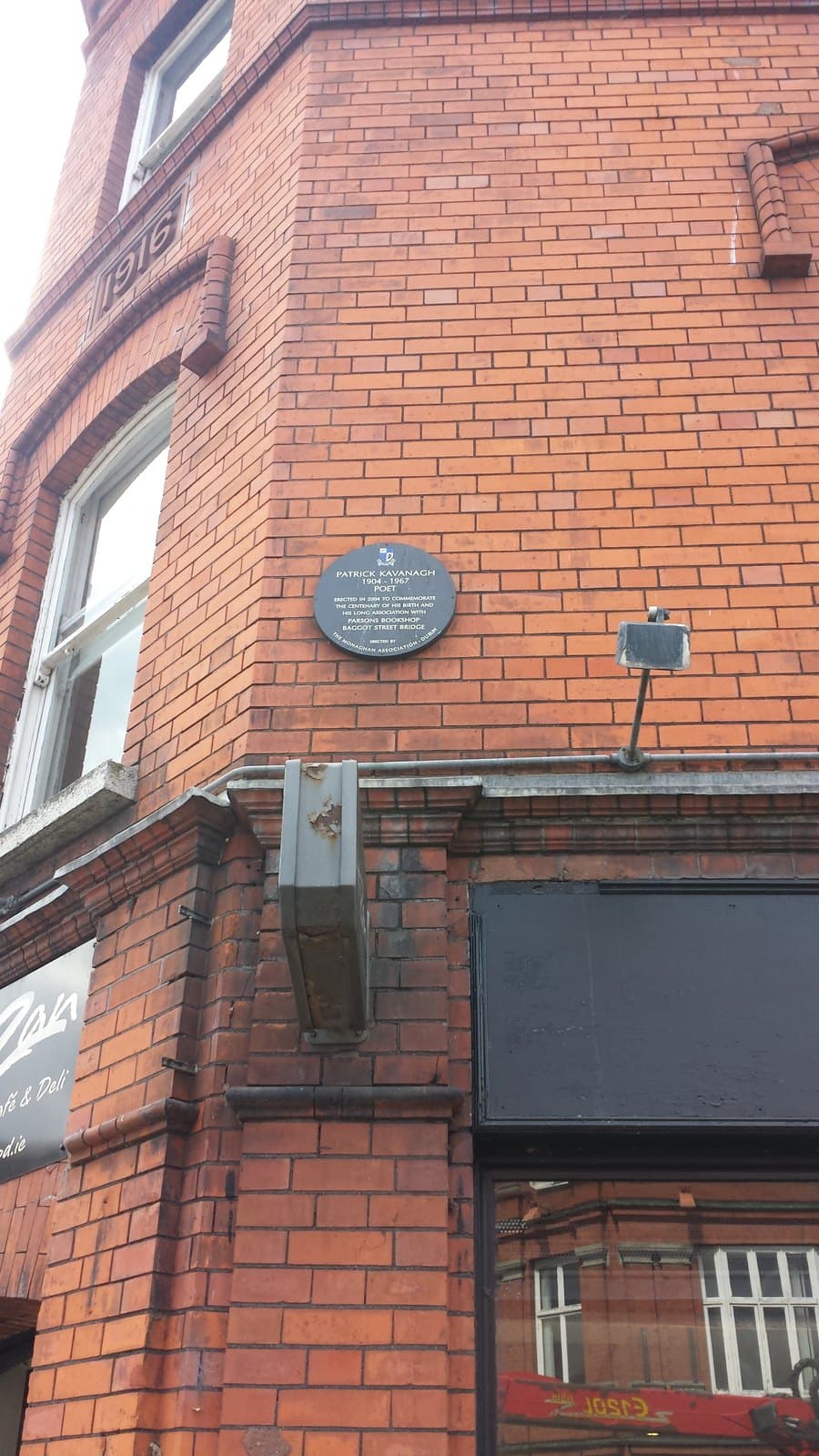 Blue memorial plaque for poet Patrick Kavanagh on a red-brick building