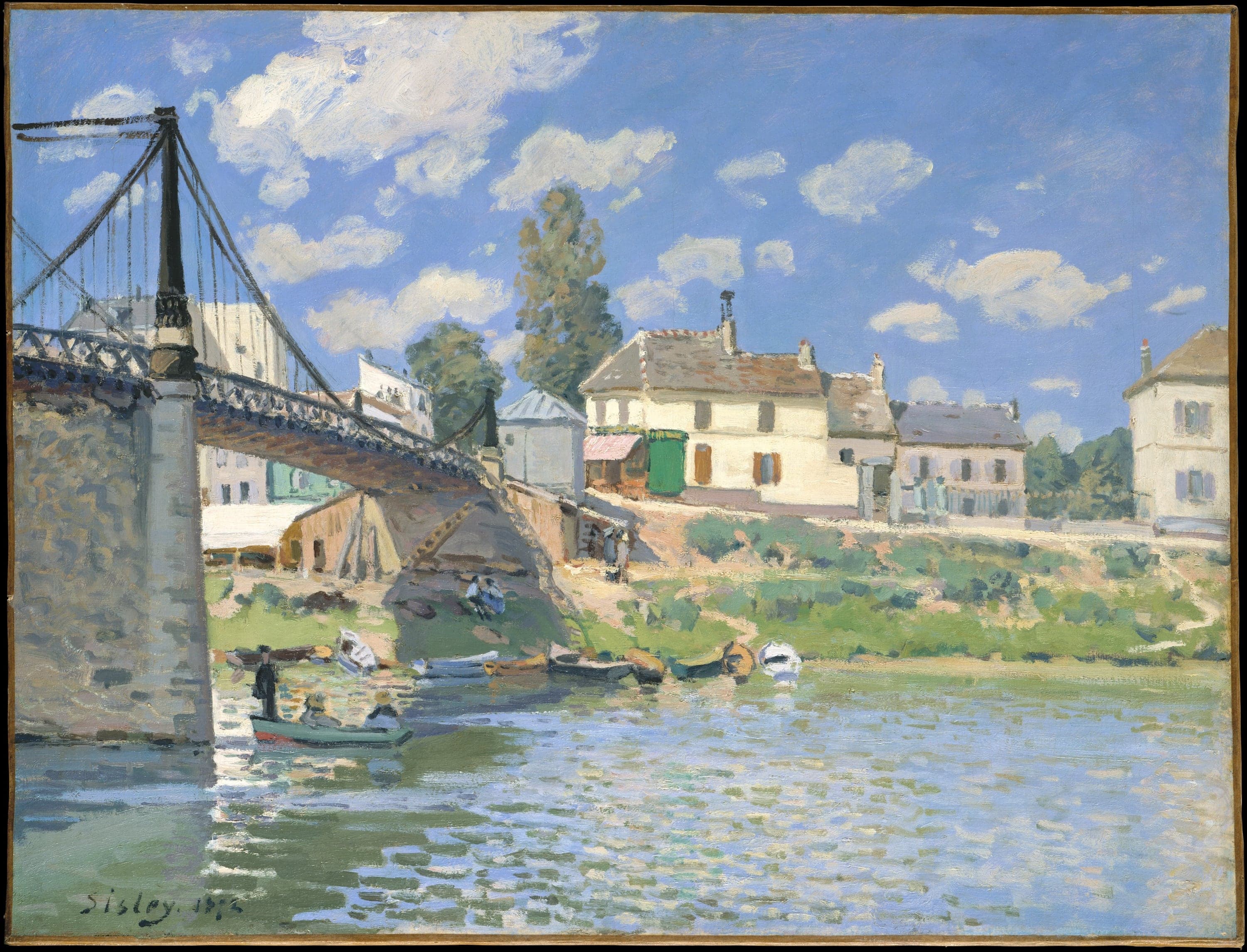 Sisley's The Bridge at Villeneuve-la-Garenne: a dark iron suspension bridge crossing the Seine from the left, its cables fanning from a tall pylon on a stone pier, a green rowing boat with three people passing beneath it, moored boats along the bank and a row of cream houses with tiled and slated roofs on the far side under a blue sky of white clouds