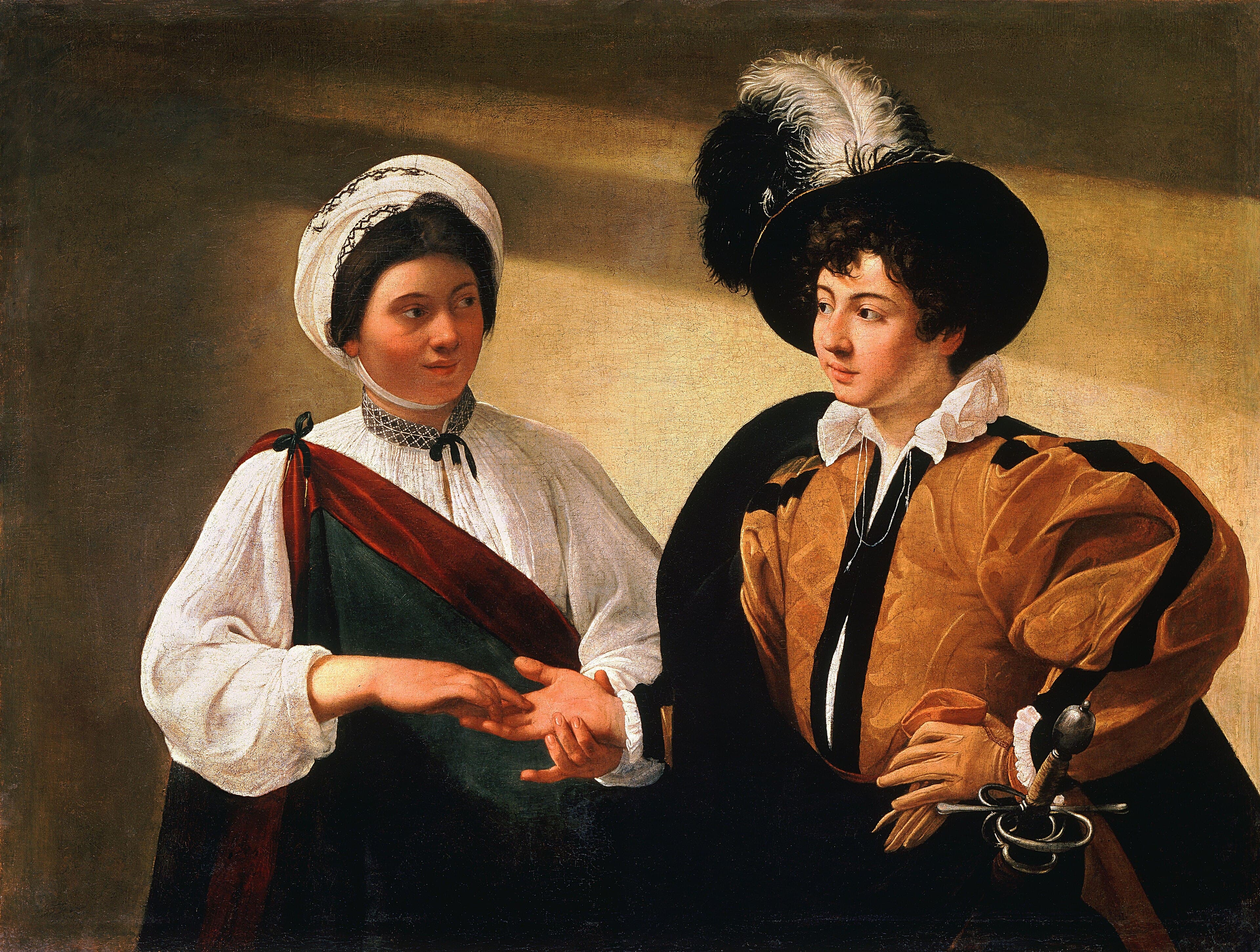 Two half-length figures against a plain olive-brown wall crossed by a diagonal band of paler ochre. On the left a young woman in a white cloth wound round her head, embroidered with a dark zigzag, wears a white blouse with a dark red sash over a green bodice; she holds the open right hand of the young man beside her and looks at his face. On the right a young man in a wide black hat with black and white plumes, a white ruff and an ochre doublet banded with black velvet looks back at her, a gloved hand at his hip and a rapier with a looped swept hilt at his side