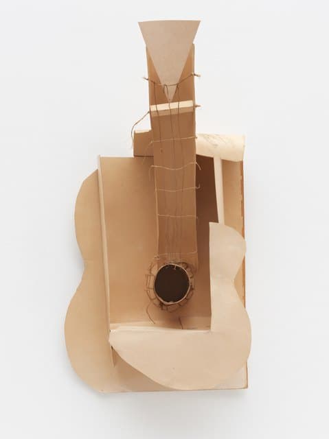 Pablo Picasso’s Guitar: a paperboard construction with an open body, projecting sound hole, strings, and angular neck.