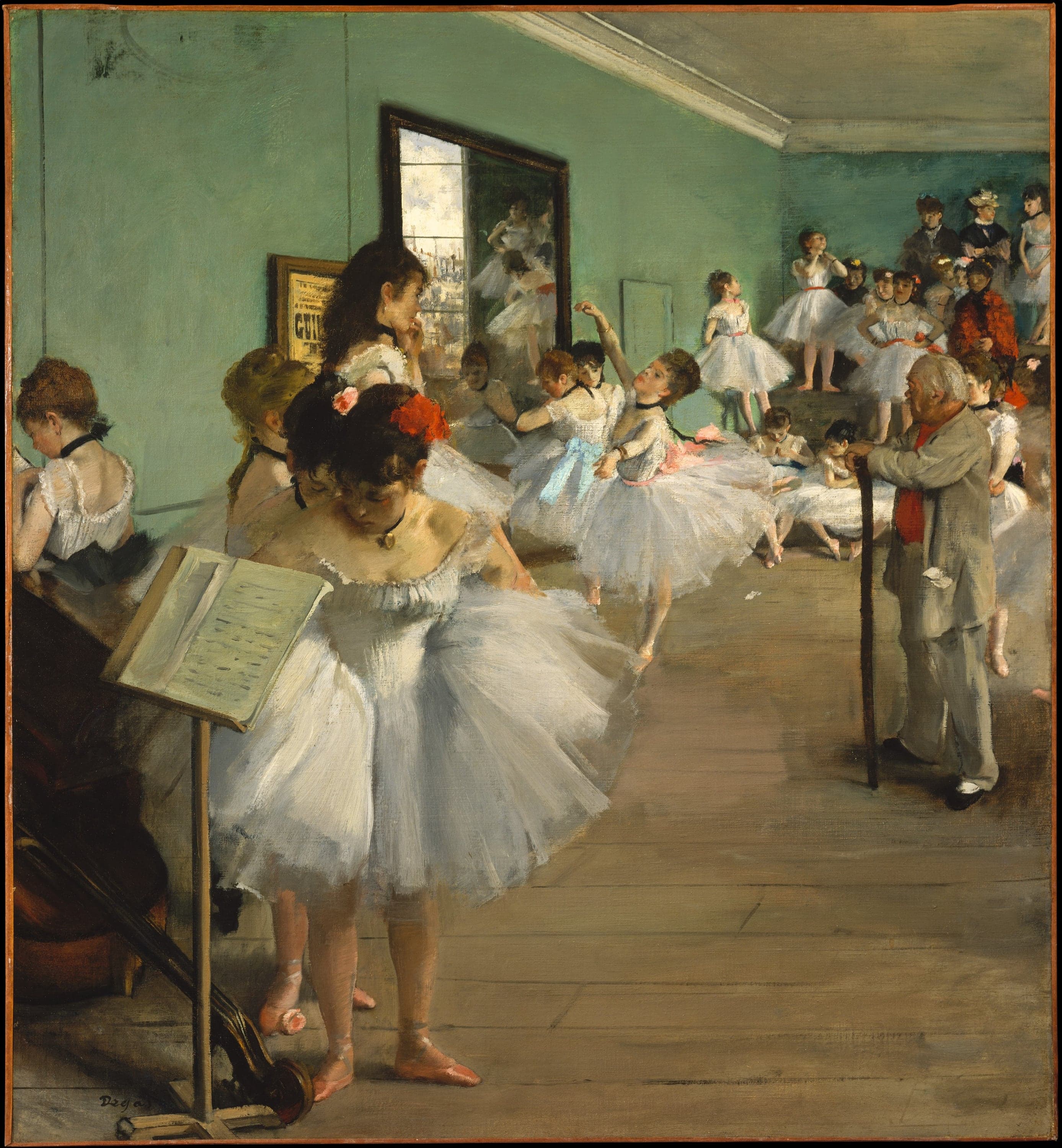 A pale green rehearsal room seen at an angle. A gray-haired man in a light suit stands in profile at the right with both hands on a long cane, watching a dancer in a white tutu hold a pose on one leg. In the foreground a dancer in white bends forward and reaches behind her back beside a music stand; the body of a double bass is cut off by the left edge, its scroll lying in the bottom corner. A framed poster and a mirror reflecting a window hang on the back wall, and about twenty more dancers and women in hats and dark coats fill the far end of the room.