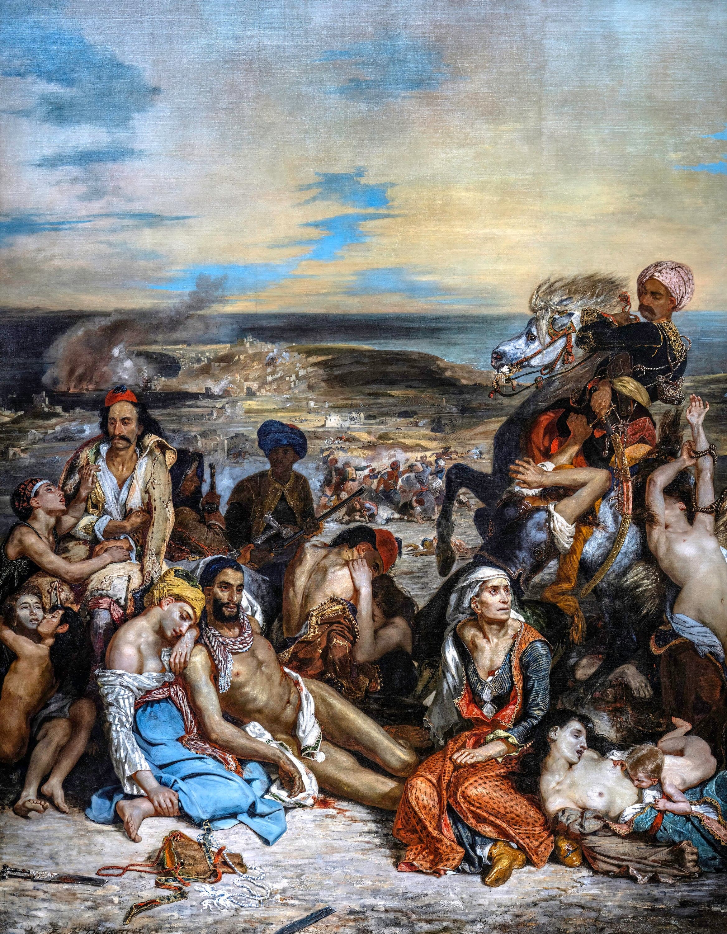 Greek civilians sit and lie in loose groups across the foreground of a tall canvas, some wounded, none resisting. At the lower right a naked infant reaches at the breast of a dead woman. Above them an Ottoman horseman turns a rearing horse with a naked woman roped across the saddle. Beyond them the ground falls to a bay, with smoke rising over a burning town on the far left
