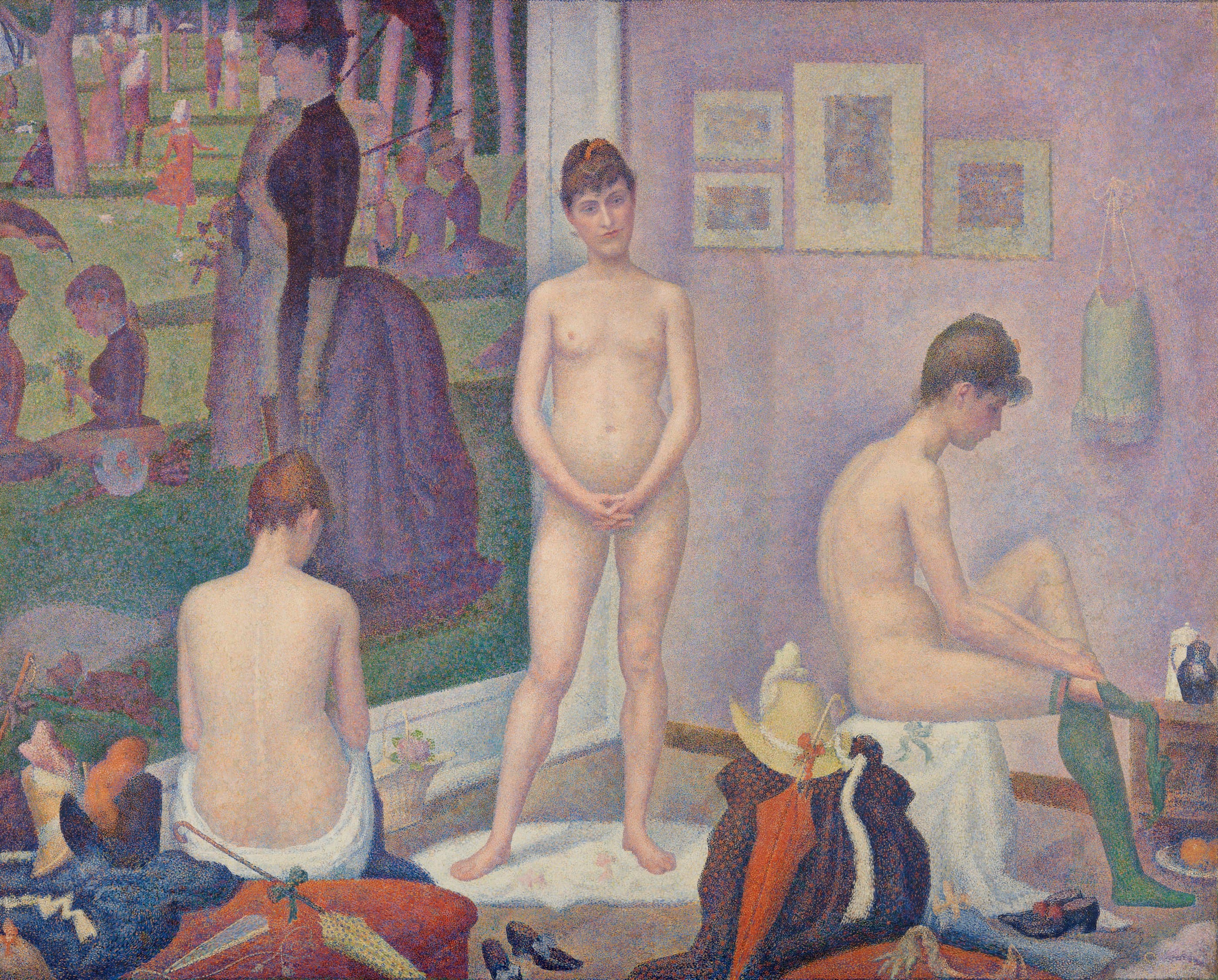 A large studio scene. On the left, part of a painted park with strolling figures hangs on the wall. Three nude young women pose in the room: one seen from behind on the left, one standing and facing us in the middle, one seated in profile on the right pulling on a green stocking. Hats, parasols, coats and shoes lie heaped on the floor, and framed pictures and a pale green garment hang on the lilac wall