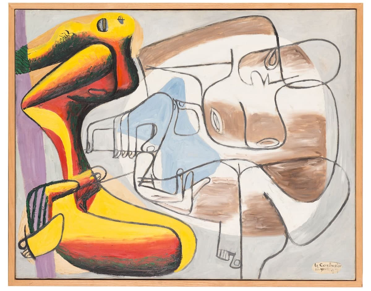 A wide painting in a plain pale wooden frame showing two figures side by side. The left figure is solid yellow and red inside heavy black outlines with dark green hatching, its head carrying one large dark eye crossed by a white bar, and a lilac stripe runs down the edge behind it. The right figure is drawn almost entirely in thin black contour line over loose brown washes on white, with a profile head and a spiral ear at the top right and an almond eye above an oval mouth in the middle. A pale blue wedge rises between them, crossed by an outlined hand with four fingers, and the signature at the lower right reads Le Corbusier over N.york 47