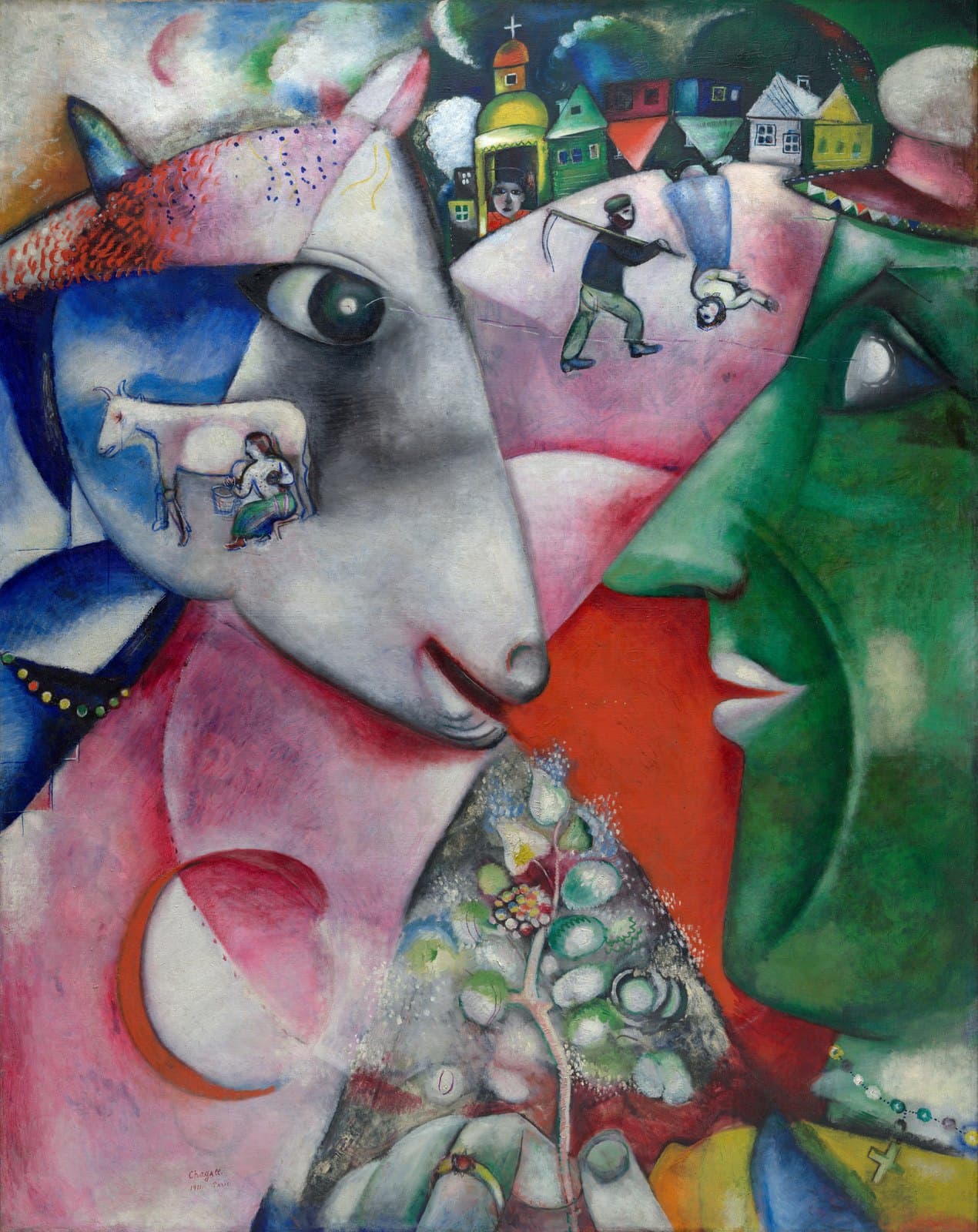 A green-faced man in profile on the right faces a pale grey animal head with one blue horn and a single large dark eye on the left, their pupils joined by a thin white line. Inside the animal's cheek a small white cow stands on a blue field above a woman in a green skirt milking it. Along the top a village of small coloured houses runs beside a church with a yellow-green dome, two of the houses upside down. Below them a man walks to the right with a scythe over his shoulder while a woman in white floats head down in front of him. A sprig of white and green blossom rises from the red and pink ground at the bottom