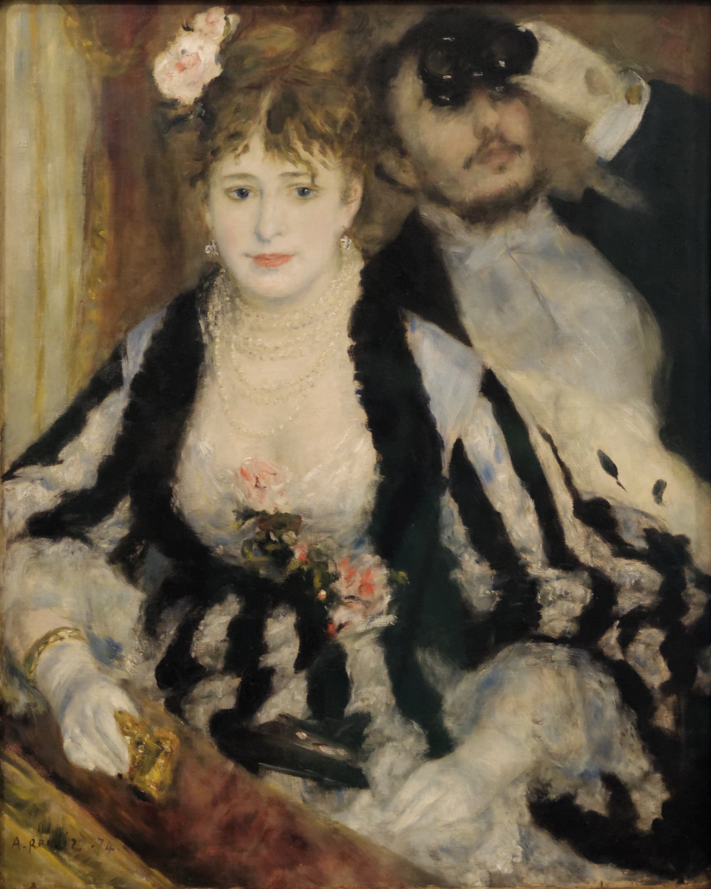 A woman in a black-and-white striped dress with black fur trim sits at the front of a theatre box, facing the viewer. Pink roses are pinned at her bodice and in her hair, several strands of pearls sit at her throat and a drop earring hangs at each ear. Her gloved hands rest on the ledge of the theatre box, one wearing a gold bracelet, the other holding lowered black opera glasses. Behind and above her a man in black evening dress and a white shirt front holds opera glasses to his eyes in a pale glove, and the glasses tilt upward, away from the stage