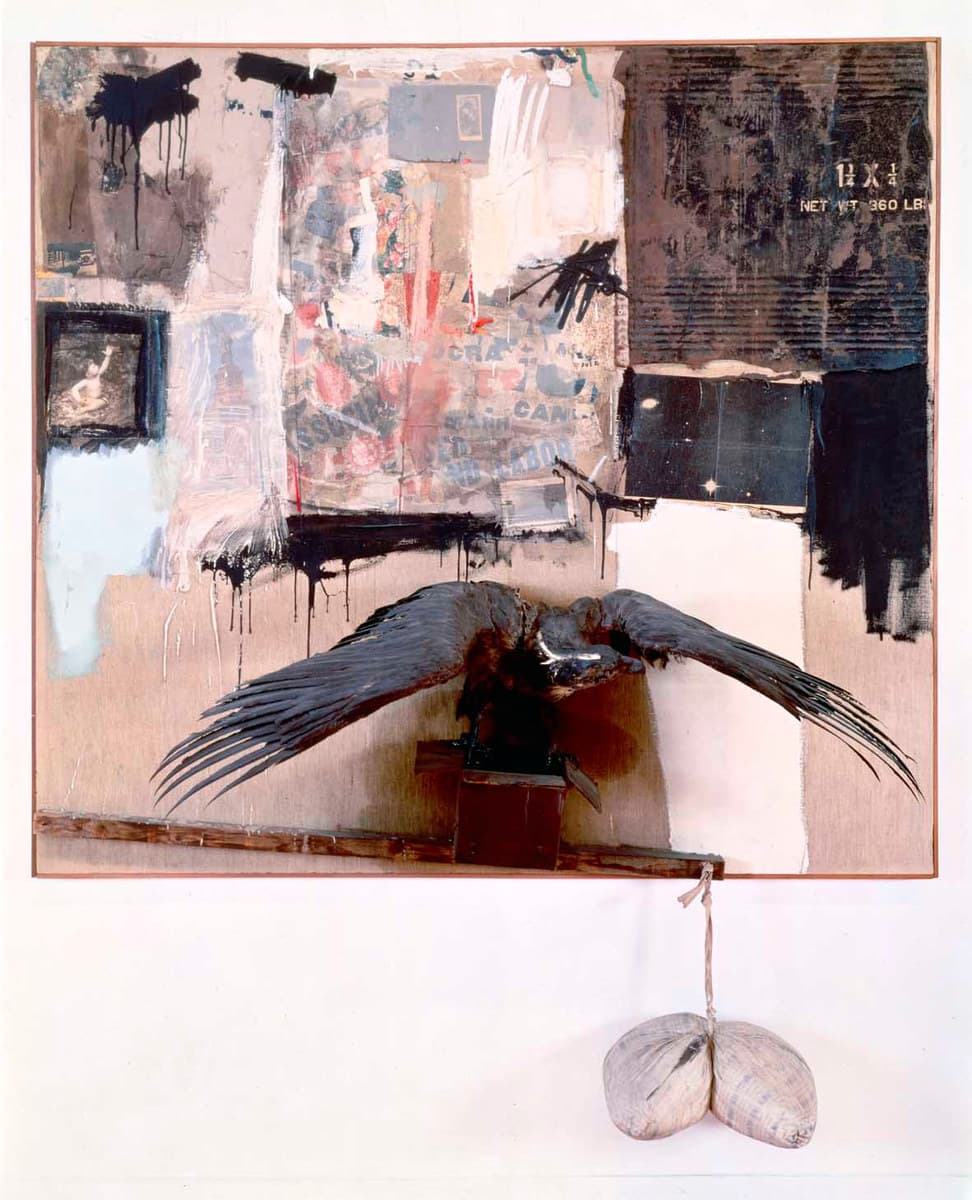 An upright collaged canvas in a thin reddish frame, photographed square on against a white wall. A taxidermied eagle stands on a dark brown box bolted to the lower half of the canvas, wings spread almost its full width with the long primaries splayed at the tips, its body and head dark. A wooden batten runs across below it, and from the batten a knotted cord drops to a pillow tied at the middle so that it hangs in two lobes below the frame. Above, a black splash drips from the top left over a small dark panel holding a pale image of a child with one arm raised; the centre is torn printed paper washed in pink and cream with fragments of blue block capitals; the right side is a dark printed board stencilled with cream capitals reading 1¼ X ¼ above NET WT 360 LB, beside a blue-black rectangle flecked with white points