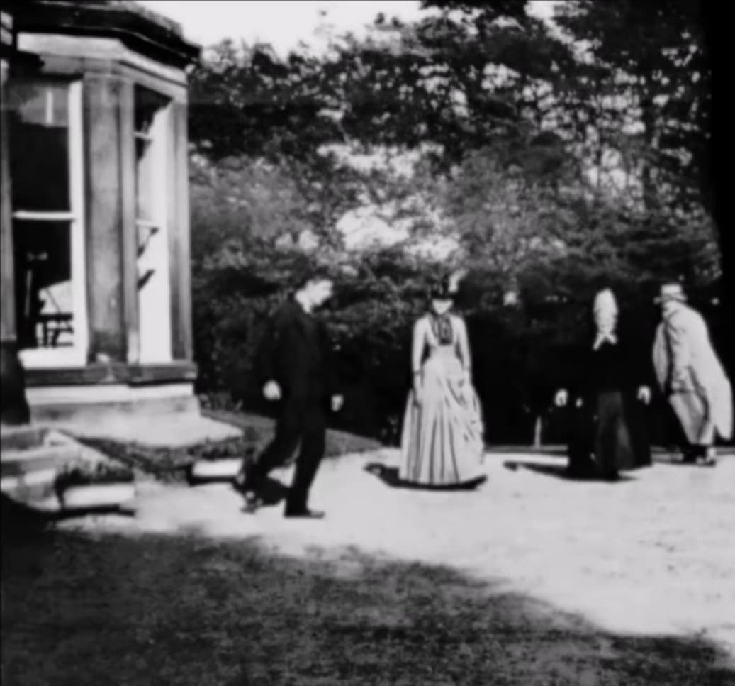 Frame from Roundhay Garden Scene showing four people in Victorian dress walking in a garden in Leeds in 1888