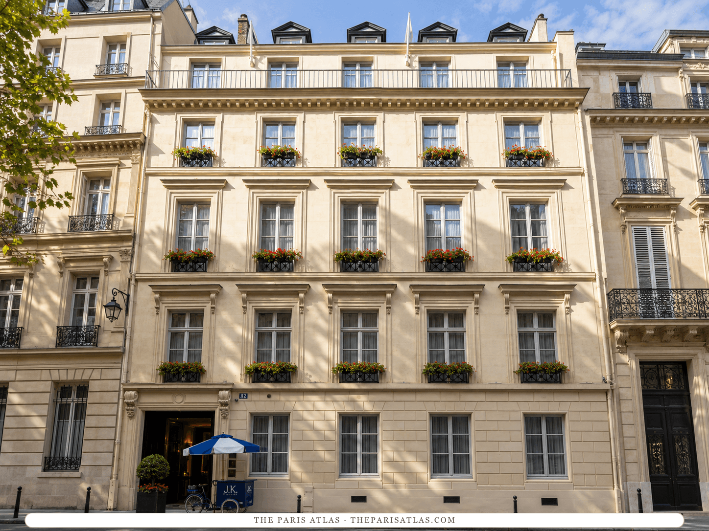 AI-generated illustration of J.K. Place Paris on rue de Lille: a pale limestone façade with rows of tall windows and flower boxes, mansard dormers, and a small cart with a blue-and-white umbrella beside the entrance.
