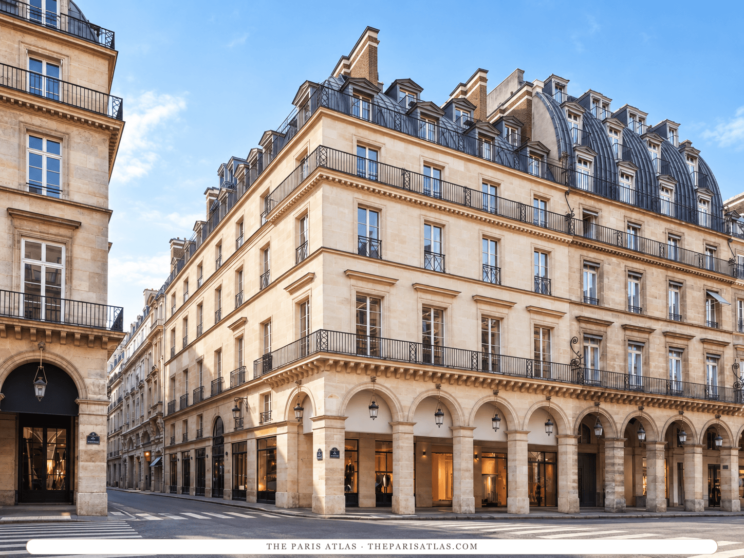 AI-generated illustration of the building that houses Maison Barrière Vendôme: a pale stone corner block with arcades at street level, long iron balconies and a slate mansard roof under a blue sky.