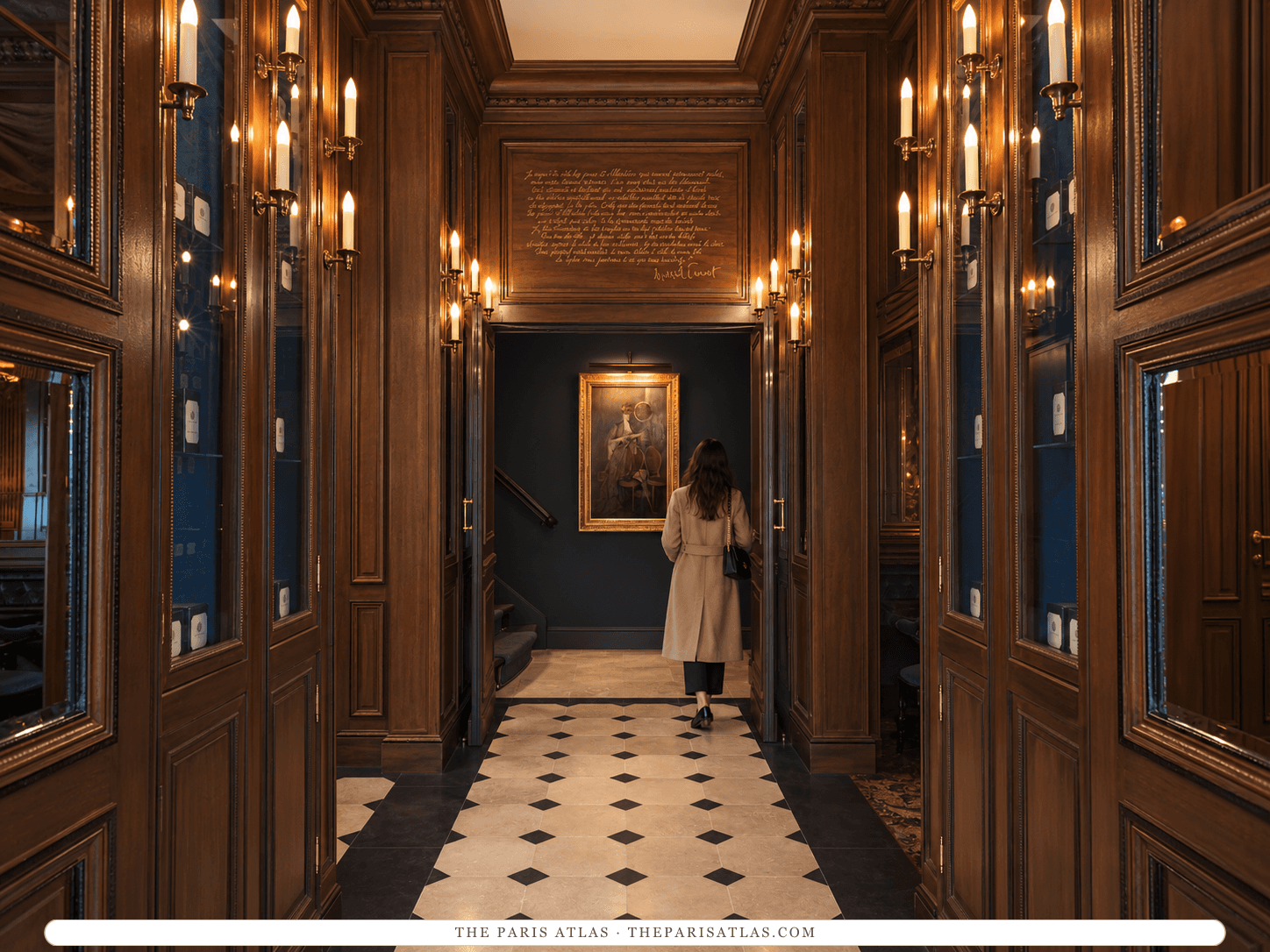 Reference-based illustration of the entrance hall at Maison Proust: a narrow corridor of dark wood panelling and mirrors lit by brass wall lights, a black-and-white tiled floor and a portrait at the far end.