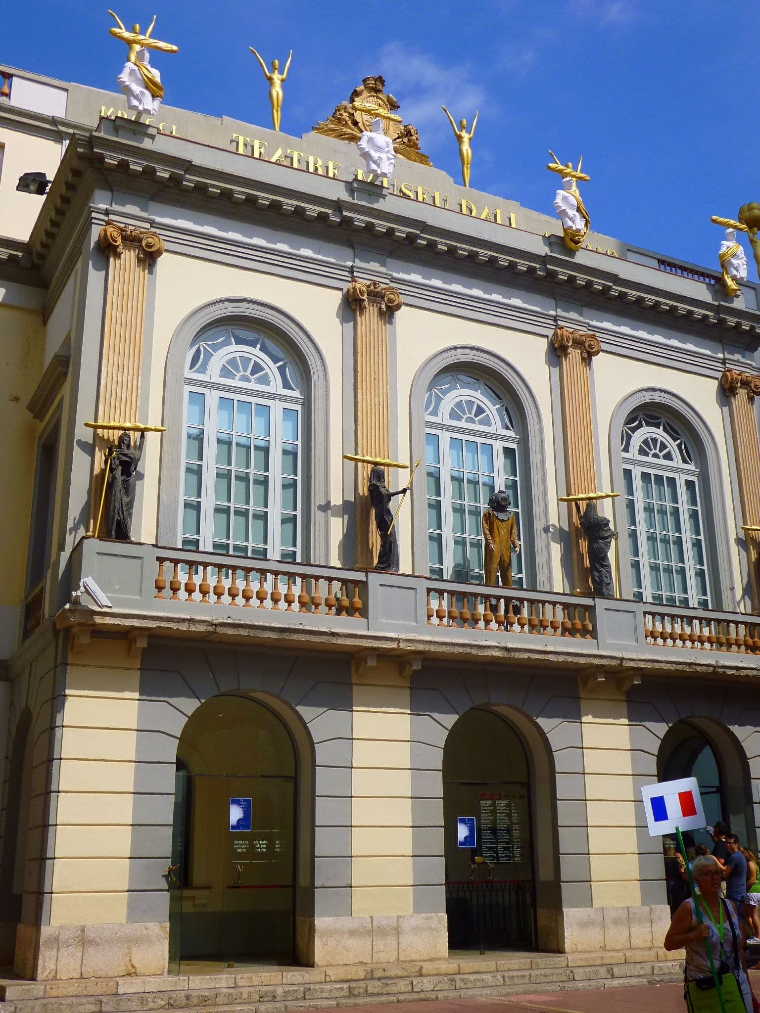 The historic theatre façade of the Dalí Theatre-Museum in Figueres, decorated with golden figures and sculptural heads