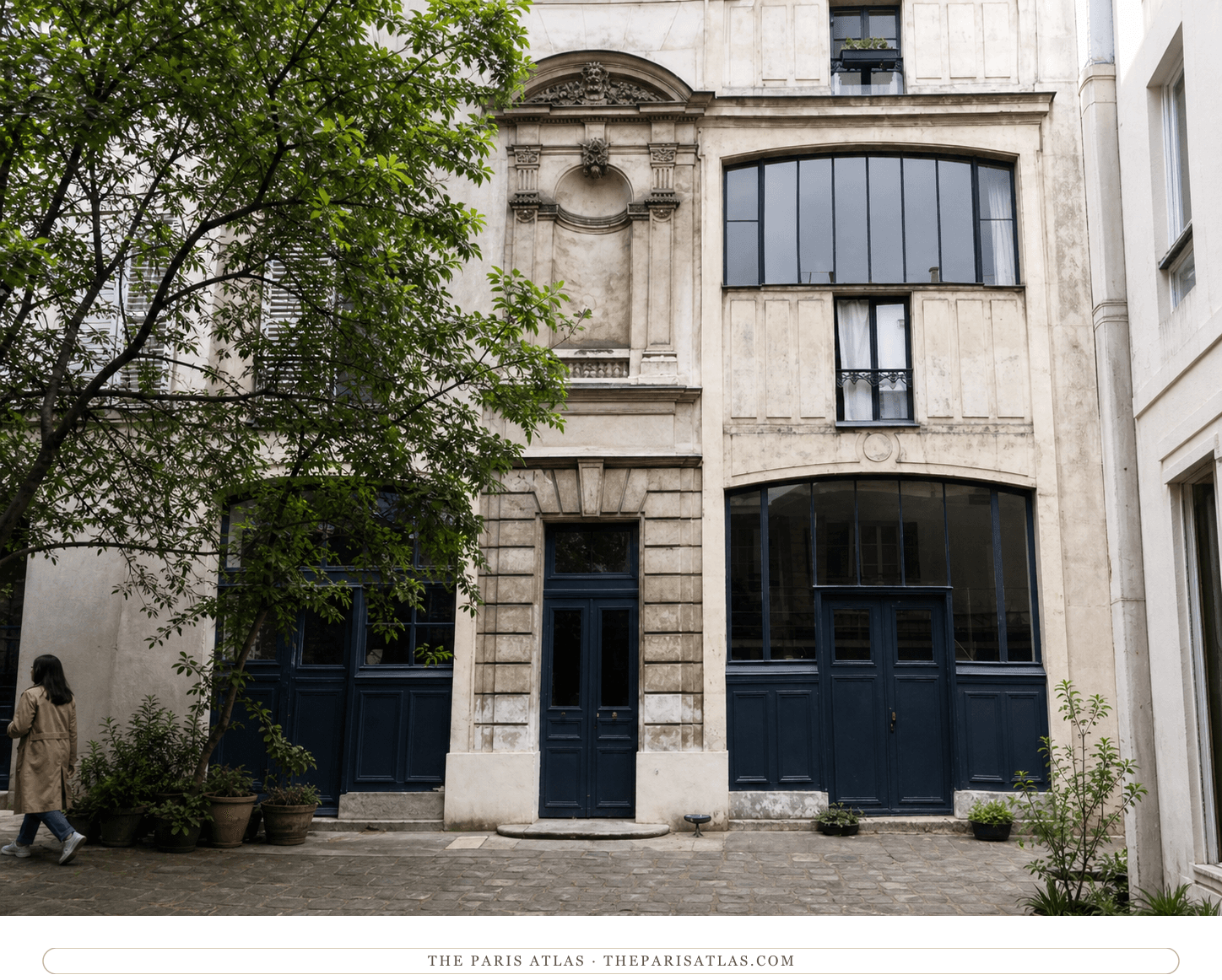 Color courtyard view of the carved entrance, studio windows and dark doors at 11 boulevard de Clichy