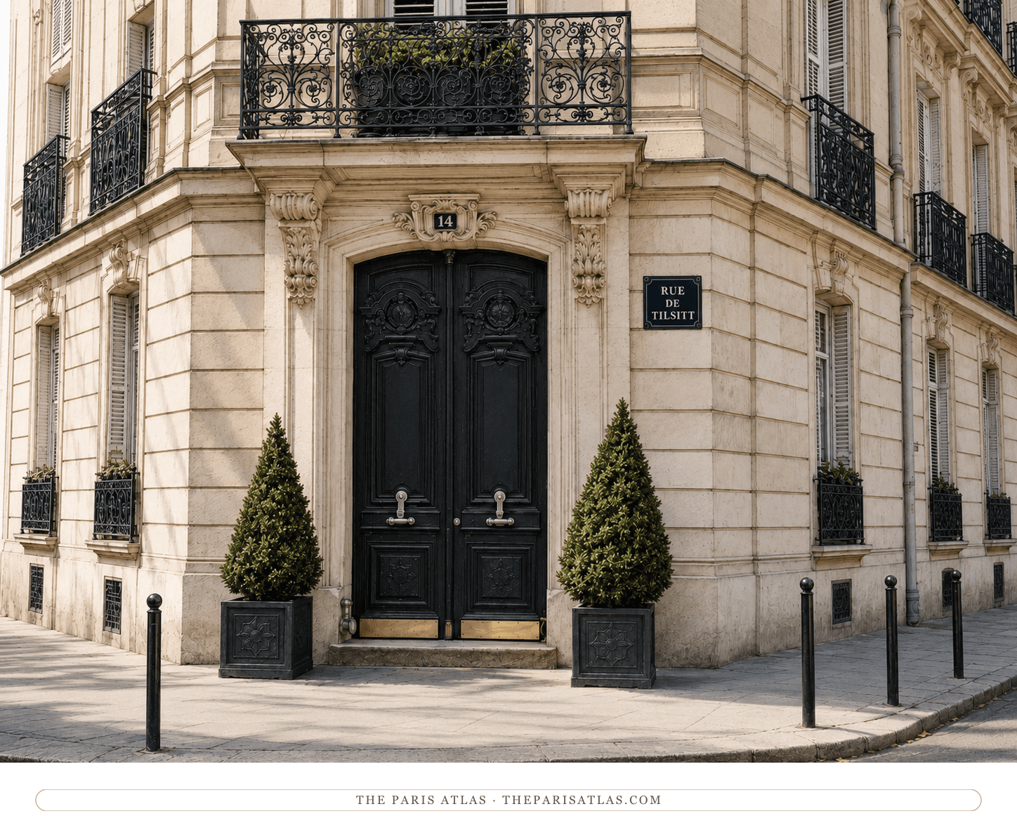 The corner entrance of 14 rue de Tilsitt today — cream stone, black double doors between two topiaries, ironwork balconies above