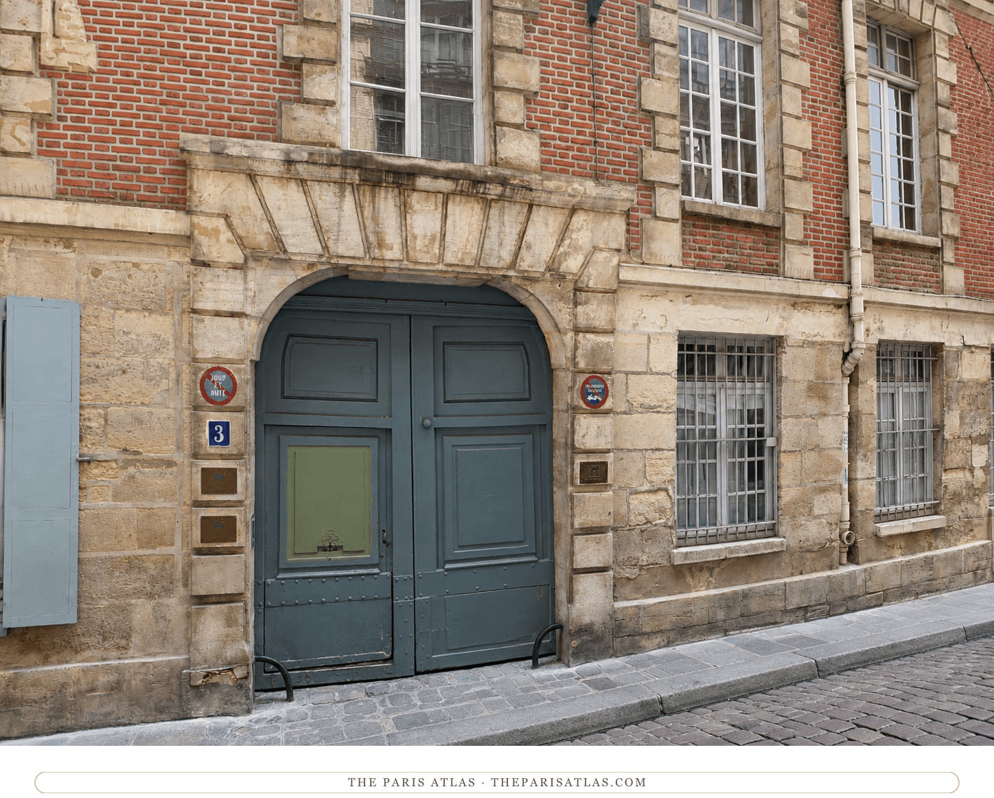 The 3 rue des Grands-Augustins doorway in color, grey-blue double doors under the stone arch, red brick above
