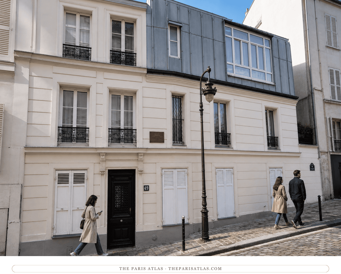 Color street view of the white façade, pale shutters and zinc studio windows at 49 rue Gabrielle