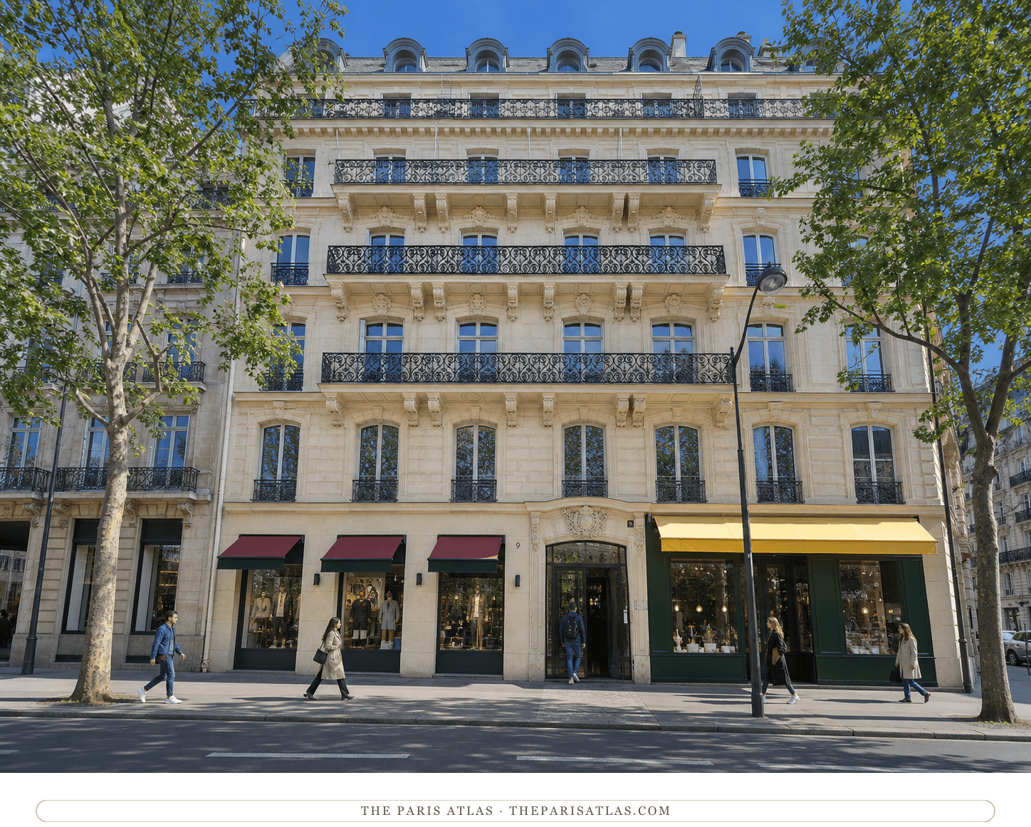 Color boulevard view of the pale stone façade, iron balconies and shopfronts at 9 boulevard Malesherbes