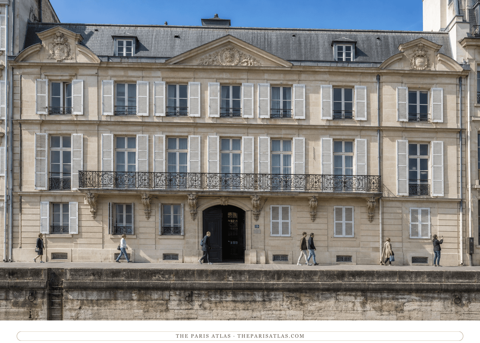 Bright color view of the long limestone Hôtel de Jassaud façade beside the Seine