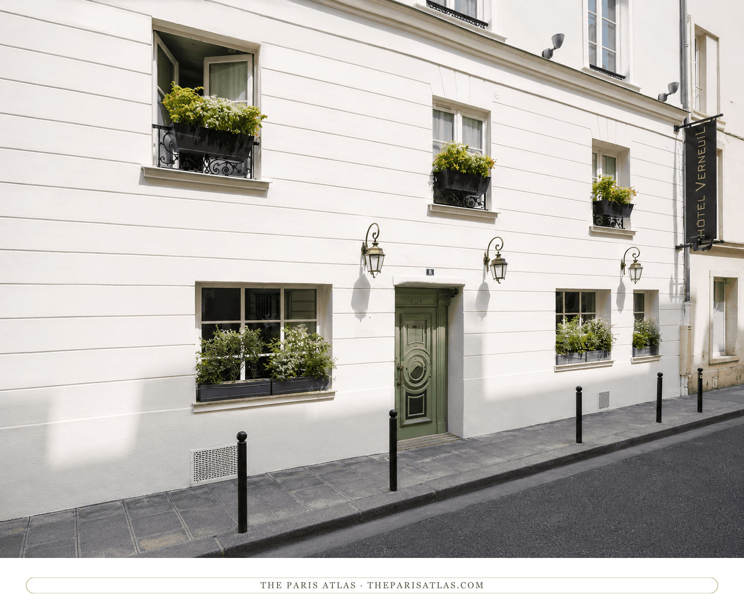 The Hôtel Verneuil today, white façade with a green front door, planted window boxes, and lanterns along the rue de Verneuil