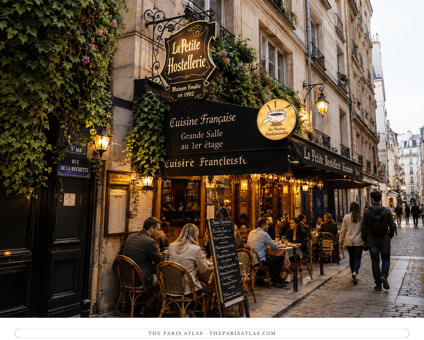 Colour drawing of a narrow Latin Quarter street, restaurant terraces under ivy and awnings, diners at pavement tables