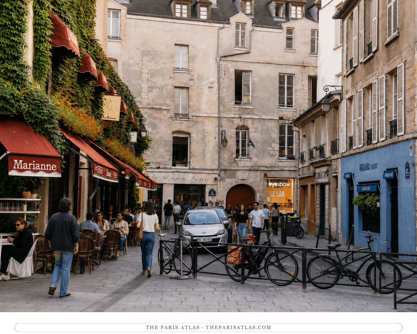 The same Marais street corner in colour, red awnings and geraniums against the ivy
