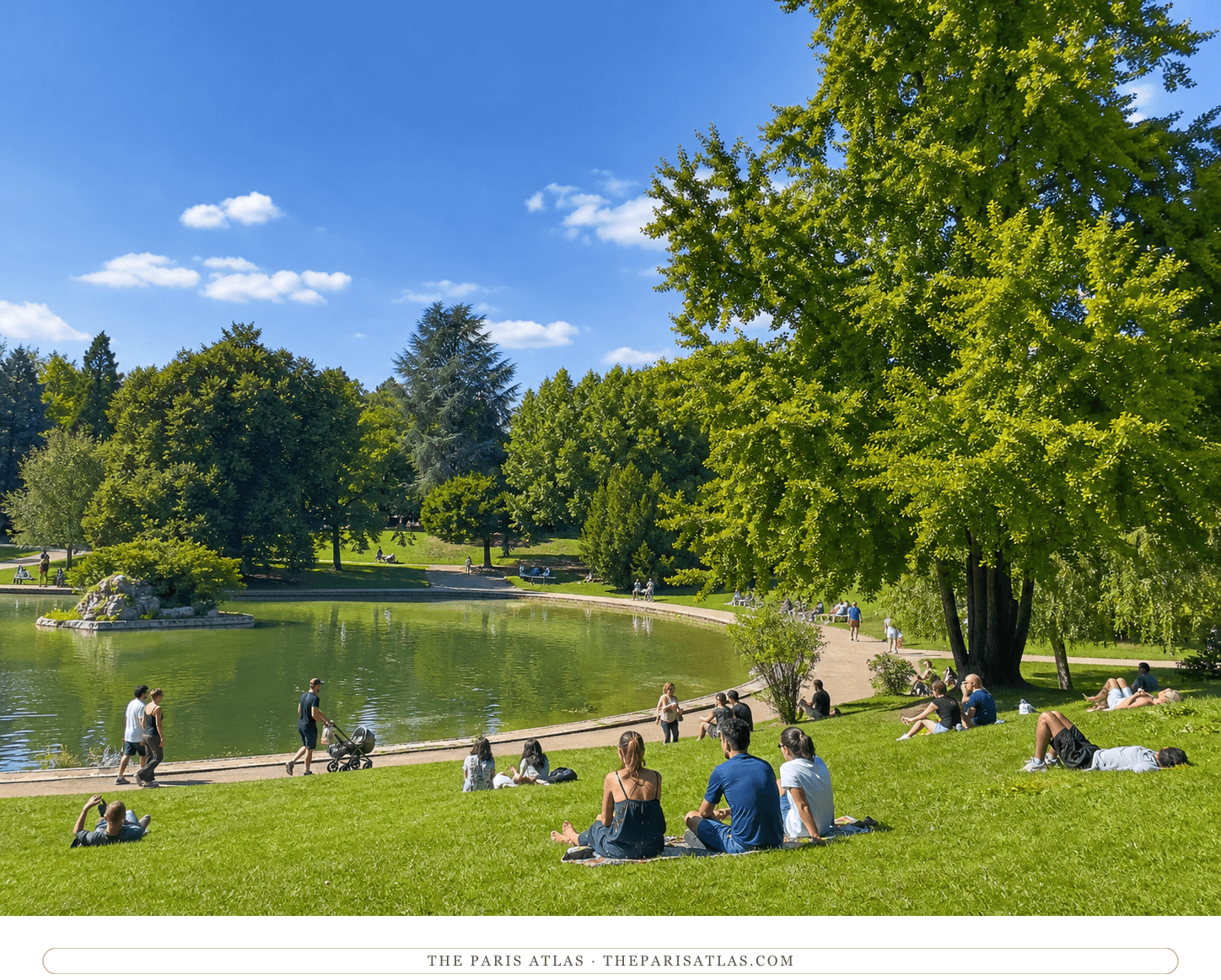 Present-day visitors beside the Parc Montsouris lake beneath a bright blue sky