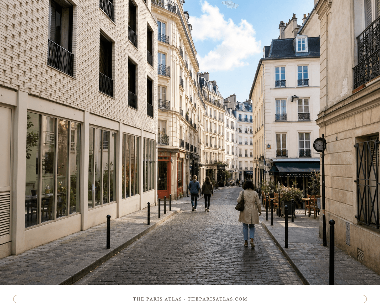 Color present-day view down rue des Trois Frères with pale façades, cobbles and a small café terrace