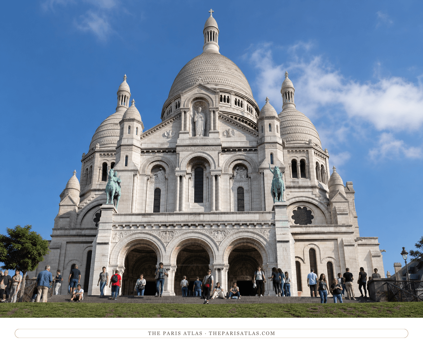 Present-day color view of the white Sacré-Cœur façade beneath a bright blue sky with visitors on the terrace