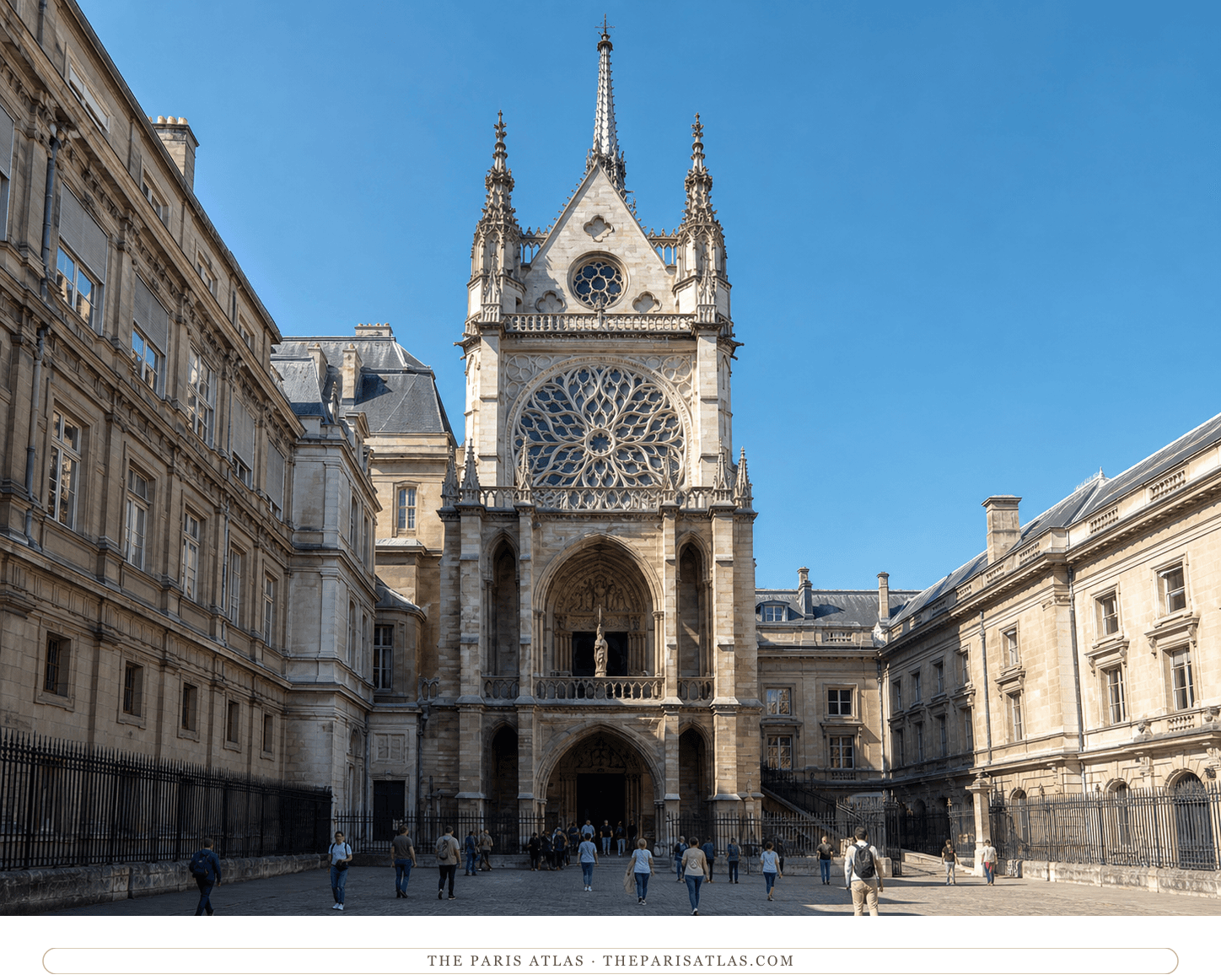 Present-day color view of the western façade of Sainte-Chapelle in bright daylight with visitors crossing the courtyard