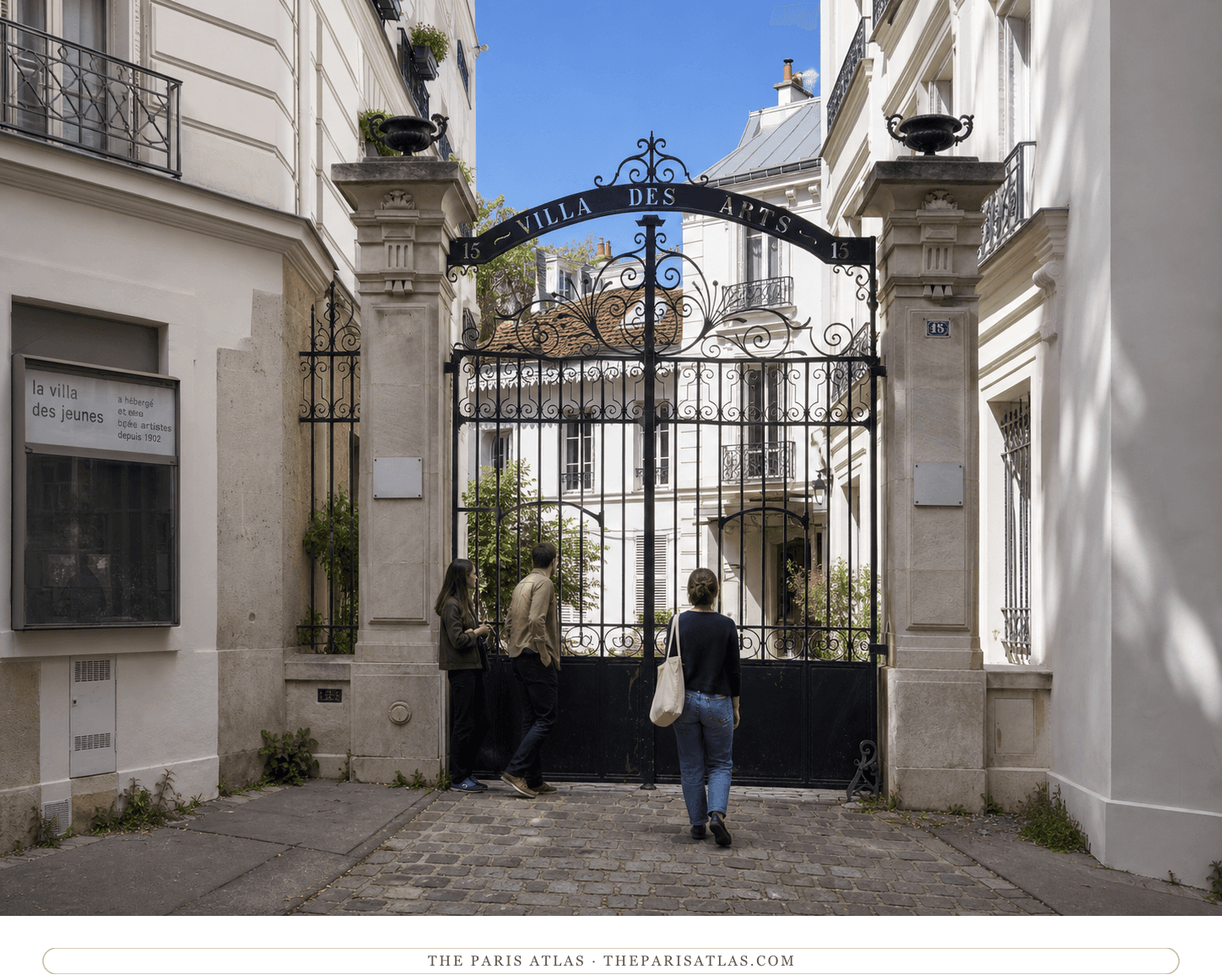 Bright present-day color view of the Villa des Arts gate beneath a blue sky
