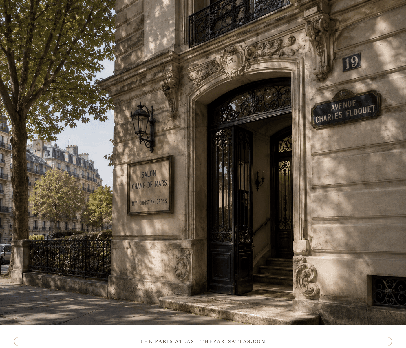 The carved entrance in warm afternoon light, the avenue's plane trees reflected along the stone