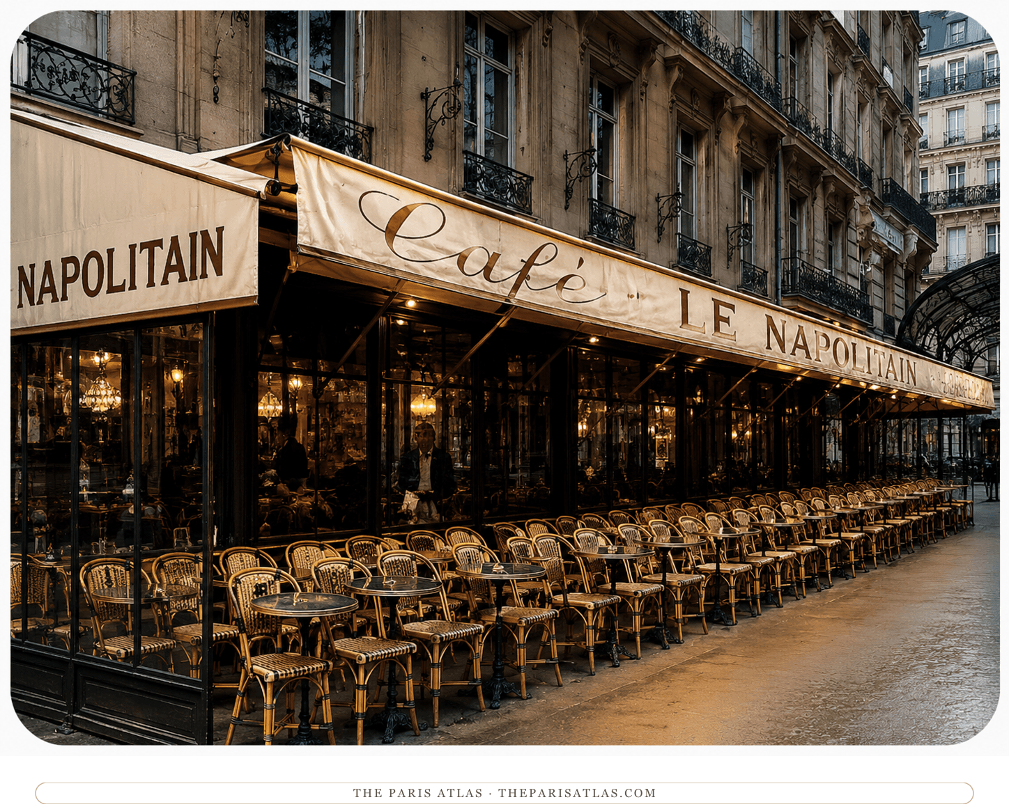 The Café Napolitain in soft evening light, empty chairs in ranks beneath the awning and the Haussmann façade above