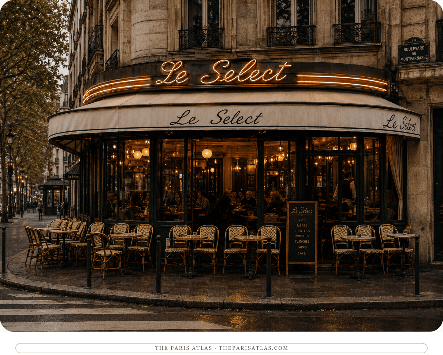 Le Select at dusk, its name in lights above the awning and the terrace chairs lined up under a warm glow