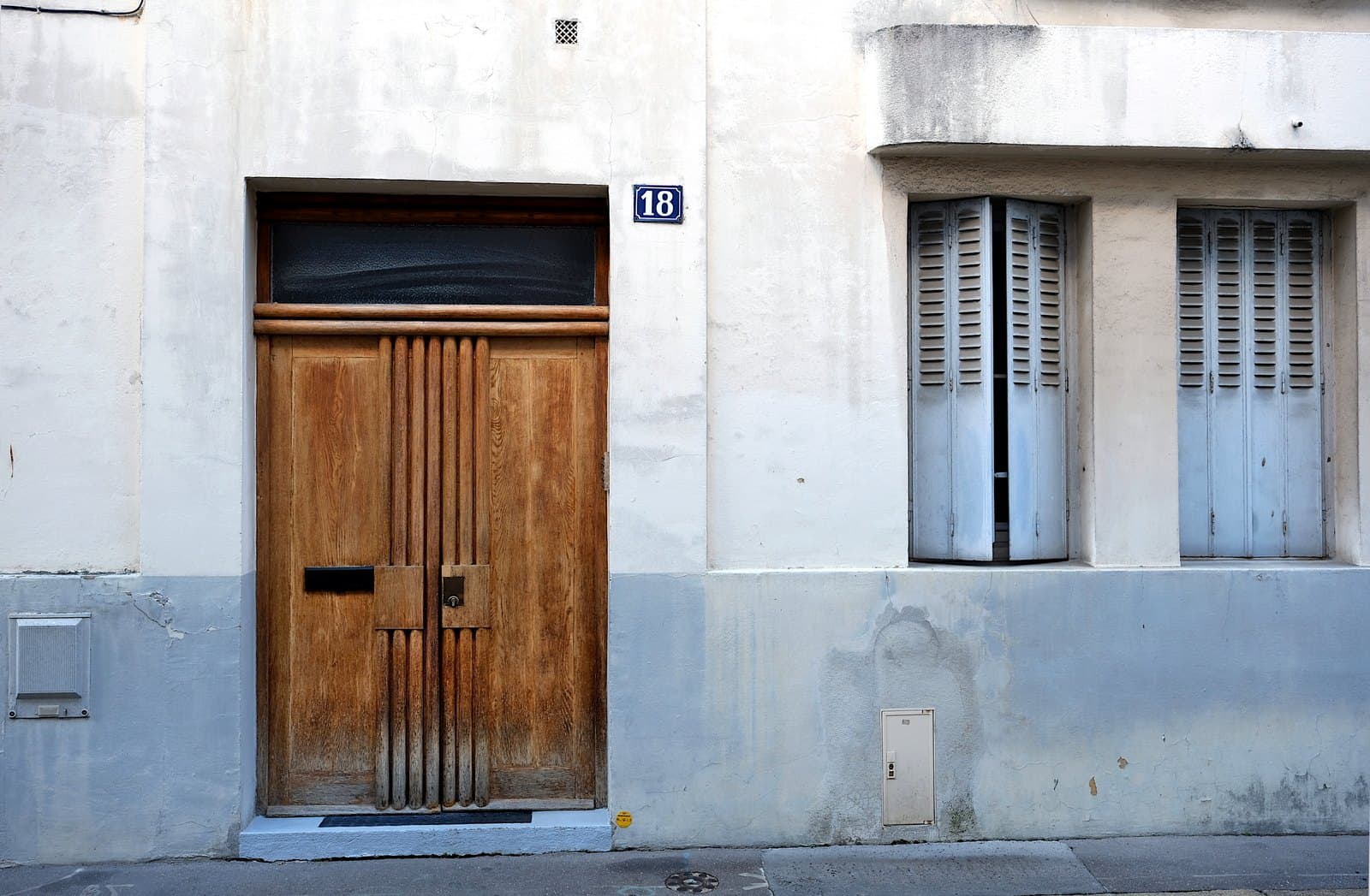 The paneled wooden door and enamel number plate of 18 Villa Seurat, Paris 14e