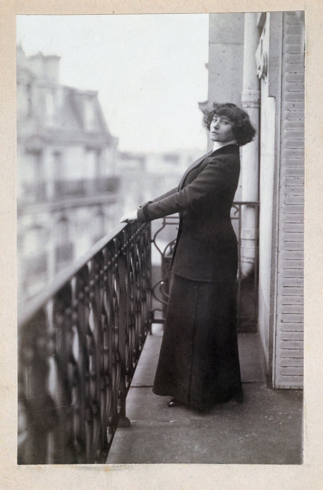 Colette seated beside an open window or balcony door late in life