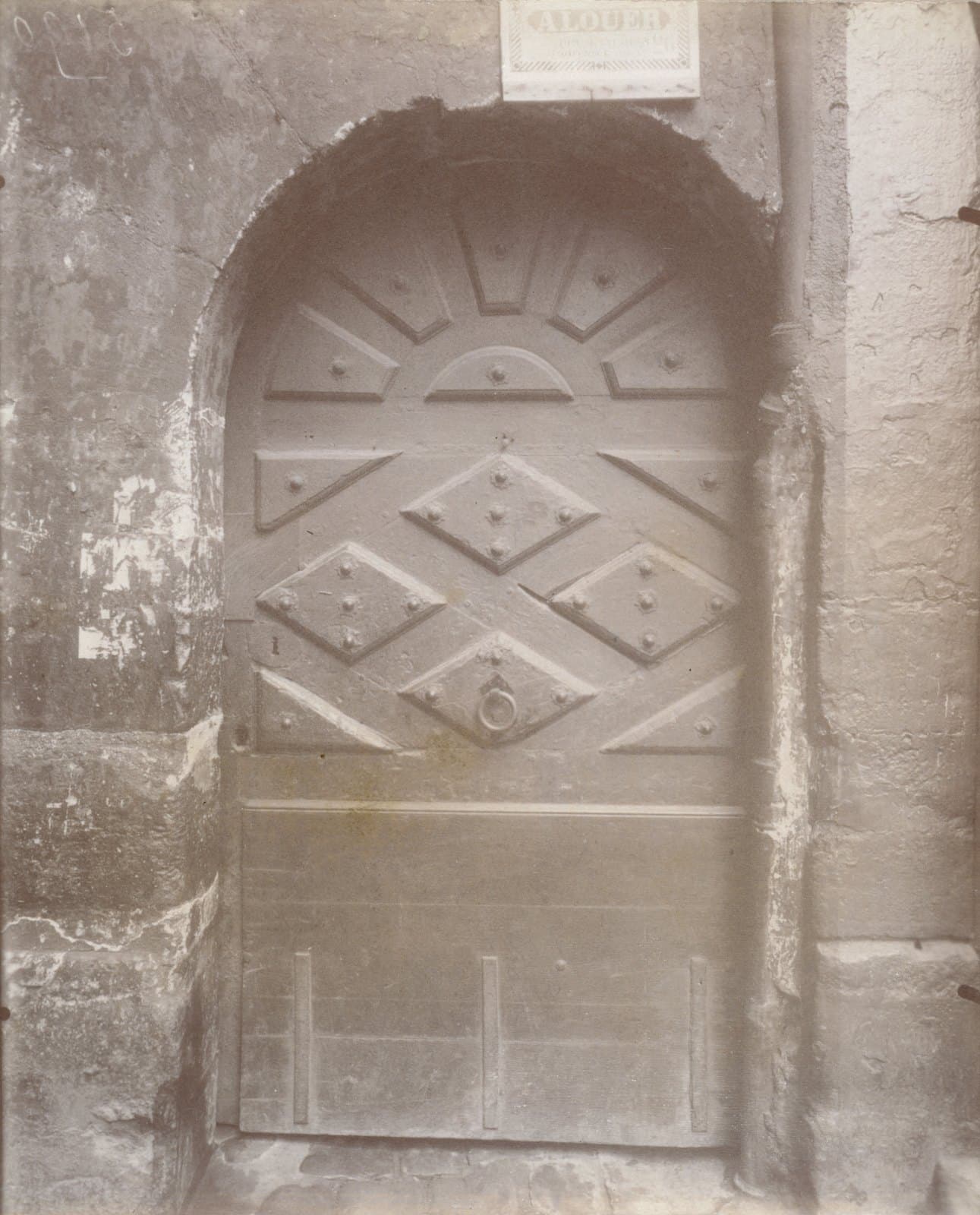 Historic photograph of the doorway at 22 rue de la Parcheminerie around 1905.