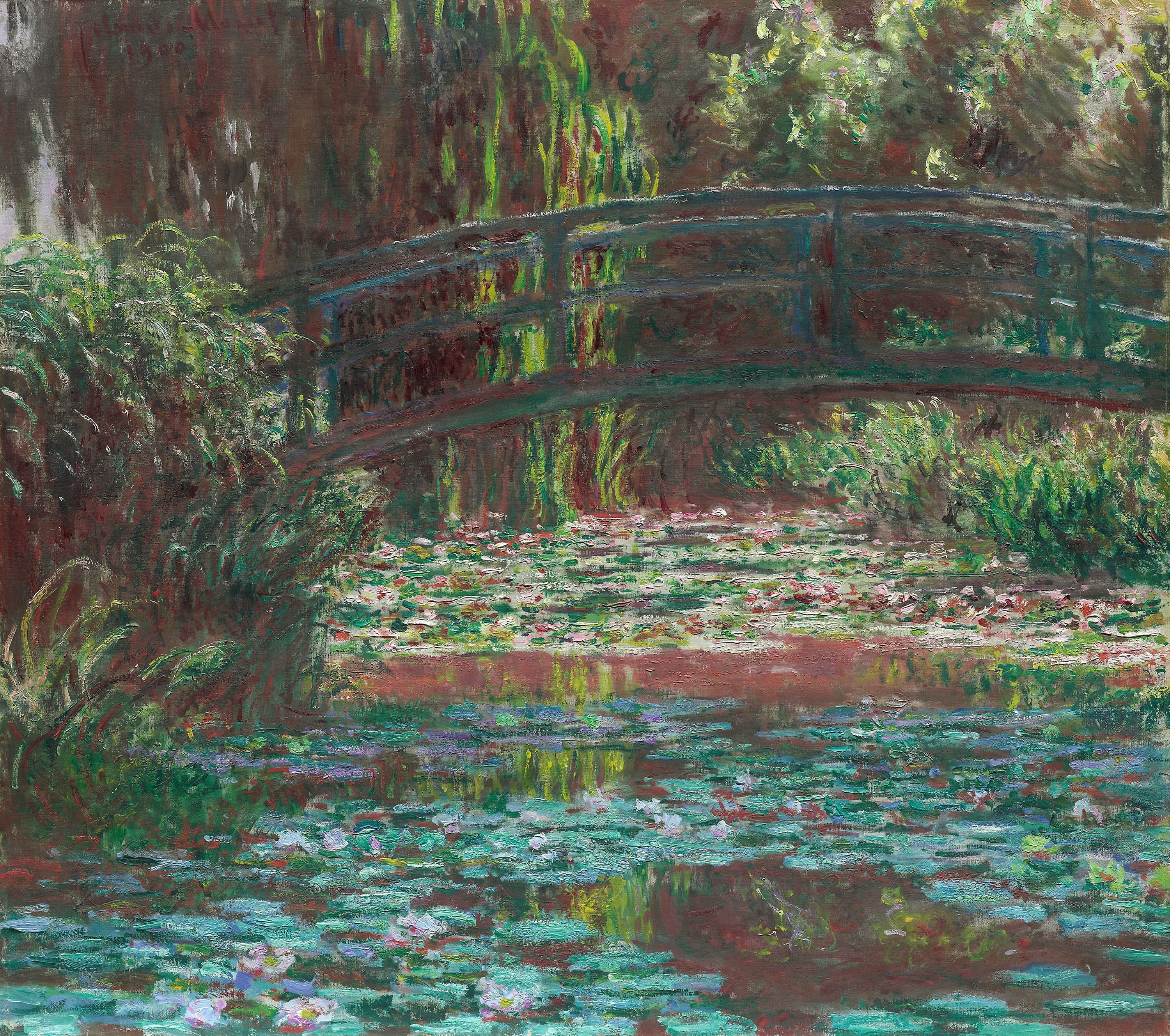Close view of the pale arched Japanese bridge crossing Monet's water-lily pond at Giverny