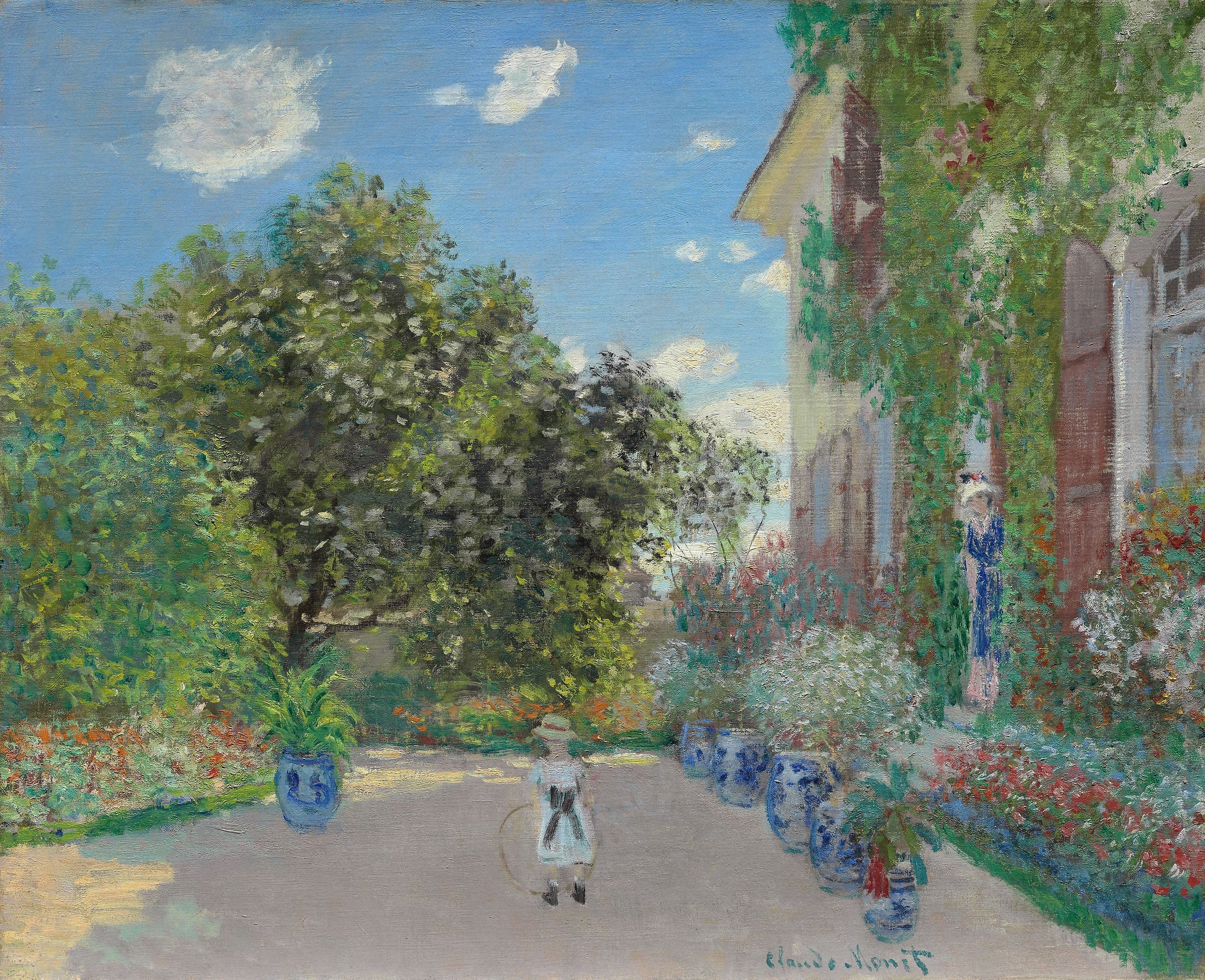 Close view of the pale stucco facade, green shutters, and sunlit windows of Monet's house at Argenteuil